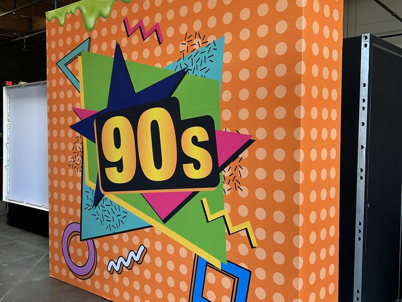 Orange 90s-themed display cube with multicolor geometric graphics