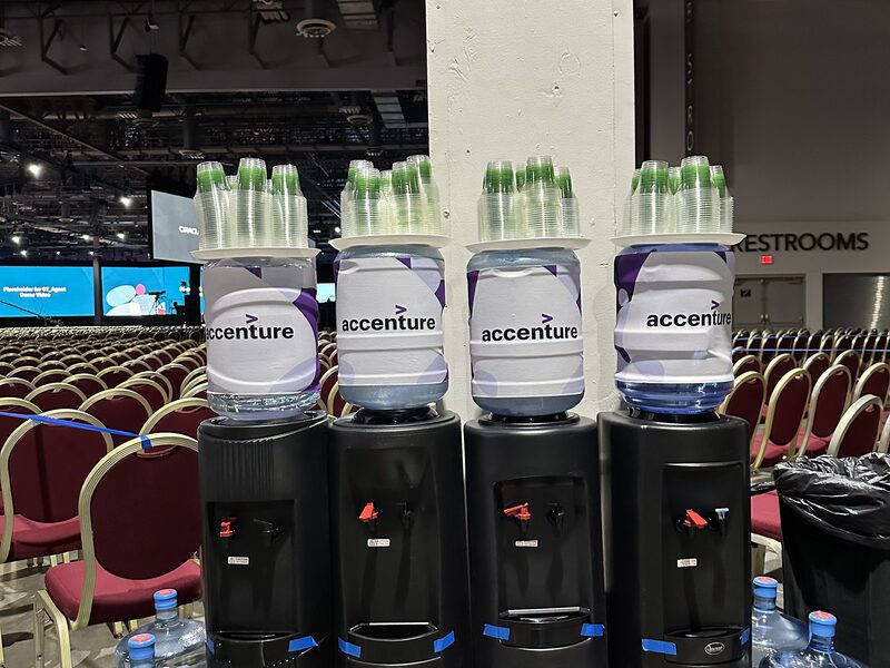 Accenture branded bottle stations arranged on black pedestals at a venue