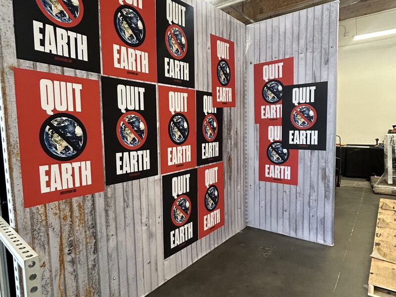 Three-sided branded event display covered with red-and-black round emblems