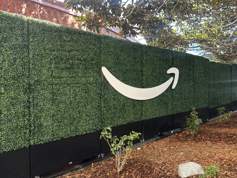 Long artificial hedge wall with a large white smile graphic