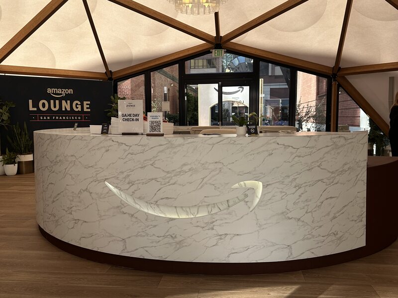 Curved marble-patterned reception desk inside an event lounge
