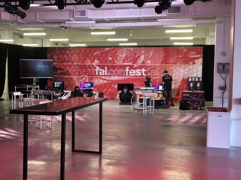 Event stage with a wide red video backdrop and production equipment