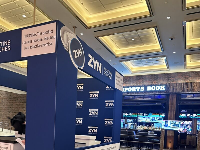 Blue ZYN promotional display with printed panels in a sports book