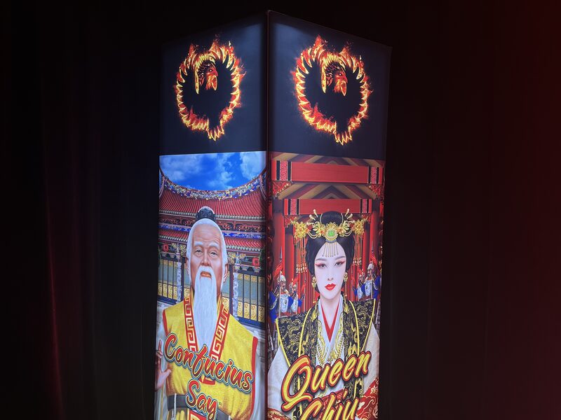 Colorful illustrated tower illuminated beneath red lanterns at a themed event