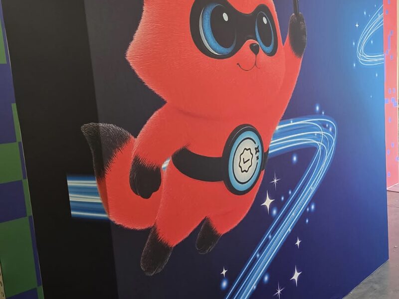 Tall printed event panel with a red cartoon character on a futuristic blue background