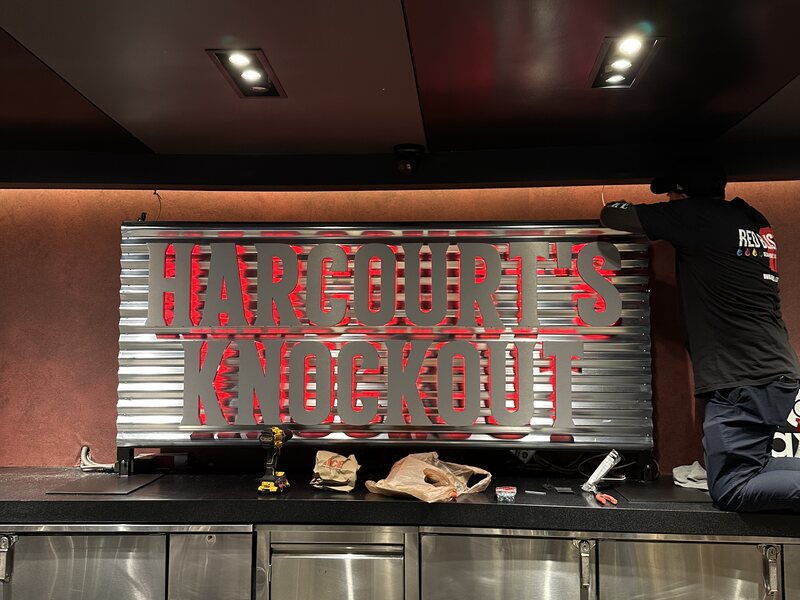 Red Hangovers Hangout lettering mounted over a corrugated metal bar wall