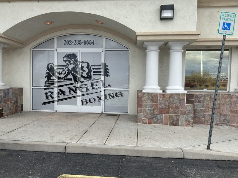 Grayscale boxing graphics applied across the windows and entrance of a storefront