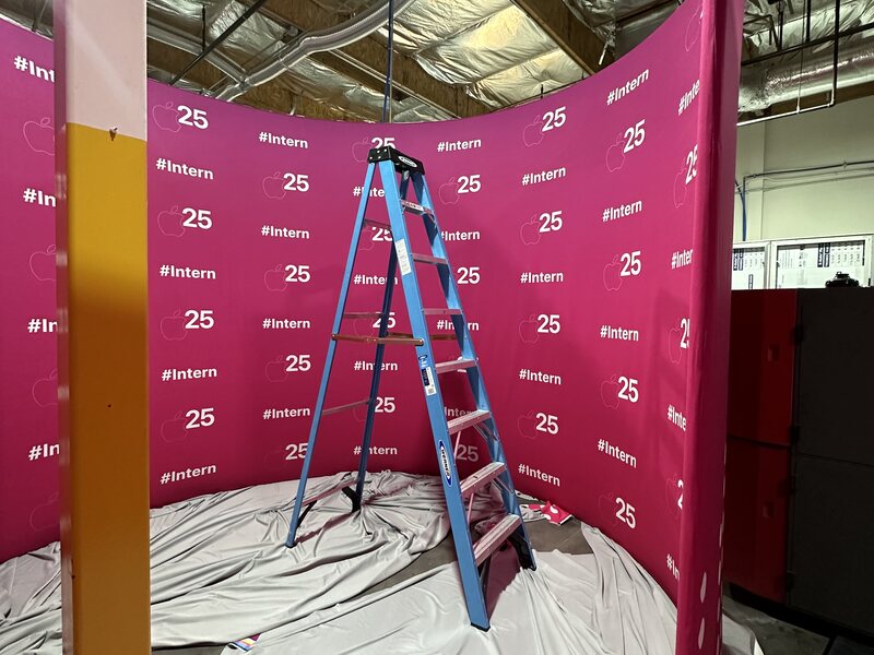 Magenta step-and-repeat walls installed around a trade show corner