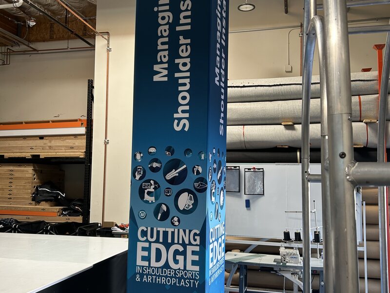Tall freestanding sign with shoulder injury graphics and lettering